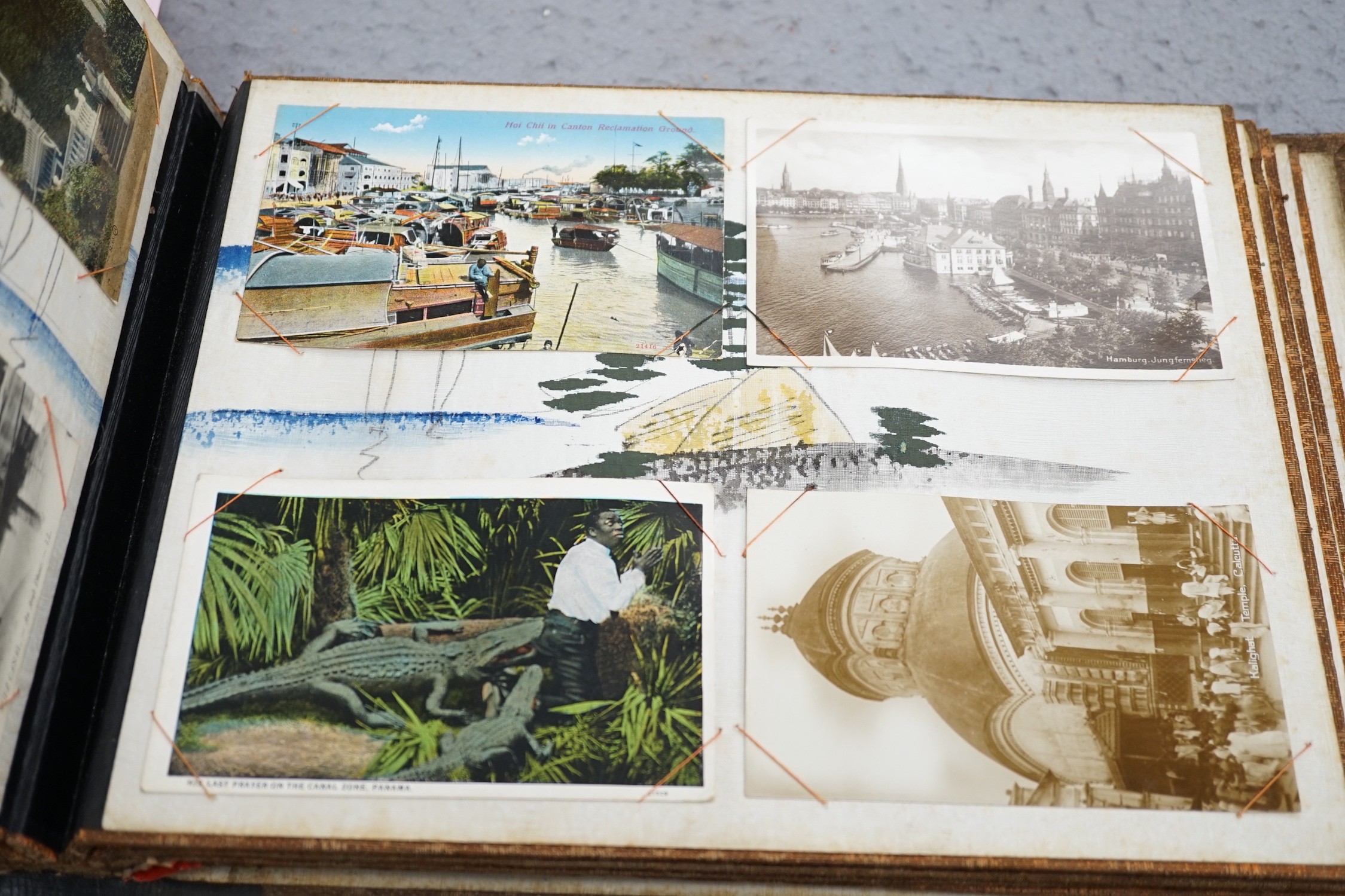An early 20th century inlaid postcard album and contents